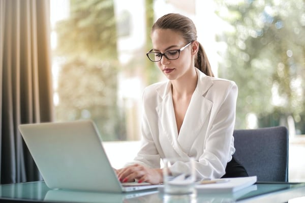 concentrated-female-entrepreneur-typing-on-laptop-in-3756681